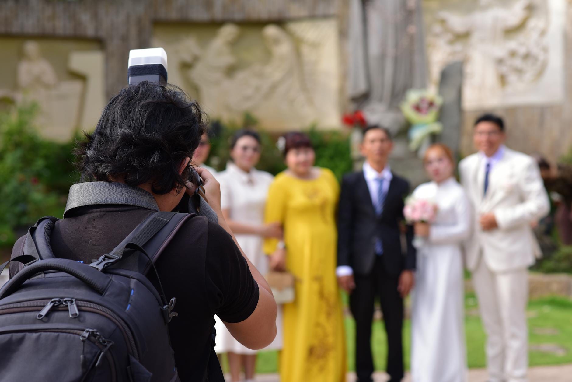 Fotograf ślubny robi zdjęcia parze młodej i gościom na zewnątrz